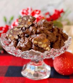 a glass bowl filled with chocolate and nuts on top of a checkered table cloth