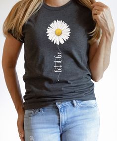 Let It Be Daisy T-Shirt Gift for Mom Flower Tee Gift for Grandma Flower Shirt Daisy Shirt for Mom Birthday Floral Shirt Gift For Her Retro Please choose the size and color of the shirt you like and then add your personalization. Enter the custom text you need on your shirt. Our solid color unisex t-shirts are super soft ring-spun cotton and our heather tees are a soft cotton-poly blend. We custom design, print, cut, heat press, and ship all our t-shirts from our retail shop in Houston, TX. We us Spring Text Print Top As Gift, Spring Tops With Text Print For Gift, Text Print Tops As Spring Gifts, Daisy Shirt, Gift For Grandma, Flower Shirt, Retail Shop, Mom Birthday, Text Design