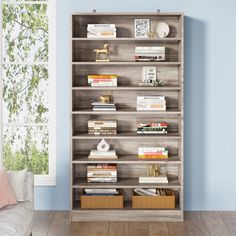 a bookshelf in a living room with blue walls and wooden flooring on the side