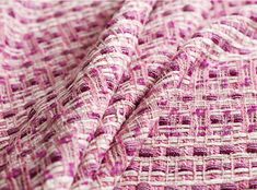 a close up view of a pink and white woven material with small squares on it