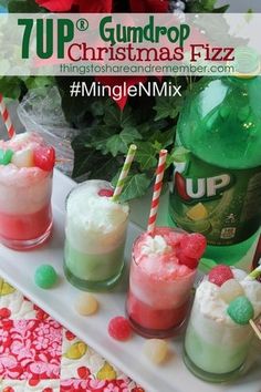 four cups filled with drinks sitting on top of a white tray next to green bottles