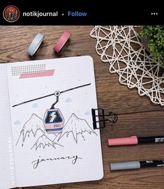 an open notebook with a drawing of a ski lift on it and some markers next to it