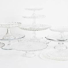 an assortment of glass cake plates and platters