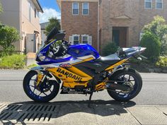 a blue and yellow motorcycle is parked on the side of the street