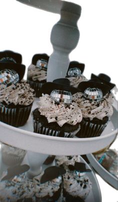 cupcakes with black and white frosting on a cake stand