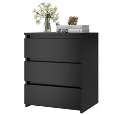 a black dresser with flowers and books on top