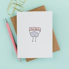 a card with an image of a cartoon character on it, next to a pen and paper clip