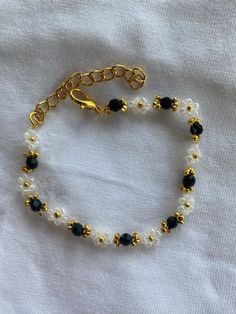 Beaded bracelet with flowers. Gold Flower Beaded Bracelets For Party, Gold Floral Beaded Bracelets For Parties, Gold Flower Bracelets With Spacer Beads, Gold Crystal Bracelet With Black Beads As Gift, Black Flower Beaded Bracelets For Gift, White Beaded Flower Pearl Bracelet, Black Flower Shaped Beaded Bracelets For Gift, Black Flower Beaded Bracelets, Black Flower Beaded Bracelet