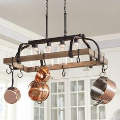 a kitchen island with pots and pans hanging from it