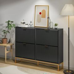 a living room with a black cabinet next to a lamp