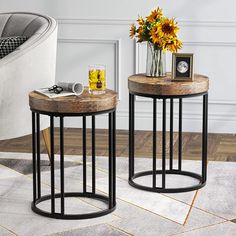 two tables sitting on top of a white rug next to a chair and vase with sunflowers