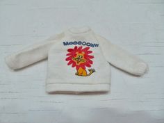 a white sweater with a lion on the front and words meeboown written on it