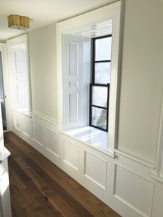 an empty room with wood floors and white walls