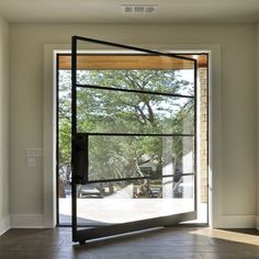 an empty room with large windows and sliding glass doors that open up to the outside