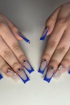 These coffin-shaped nails present a royal vibe with their sparkling deep blue tips that transition to a clear base. Each nail is embellished with intricate silver glitter designs, adding a touch of elegance and glamour. Eye-catching and sophisticated, these nails are a stunning choice for a show-stopping prom night. ✨  // Photo Credit: Instagram @nailssbyyuleth Royal Blue Nails For Prom, Cute Prom Nails, Royal Blue Prom Nails, Prom Nails Blue, Blue Sparkly Nails, Navy Blue Nail Designs