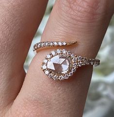 a close up of a person's hand with a diamond ring on their finger