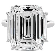 an emerald - cut diamond ring with three baguets on the shoulders and sides