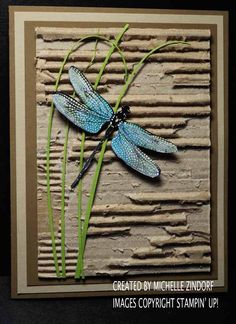 a blue dragonfly sitting on top of a green plant