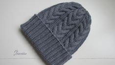 a gray knitted hat sitting on top of a white table