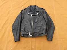 Vintage estimated 1980s Schott Perfecto black leather motorcycle jacket- tag is missing, main zipper is branded Schott. In good condition, general wear to leather including some damaged areas (right front shoulder has some peeling), light wear to collar, glue marks on both sleeves, scratches, wear to cuffs, end of belt is damaged, zipper has some tooth damage but works fine. Looks great, ready to wear, sold as-is. No size marked, fits Men's Small to slim Medium. Measurements, in inches with garm Vintage Biker Jacket For Streetwear With Zip Detail, Vintage Black Leather Jacket With Front Zip, Schott Perfecto, Black Leather Motorcycle Jacket, Flight Jacket, Shoe Size Conversion, Leather Motorcycle Jacket, Military Fashion, Mens Fitness