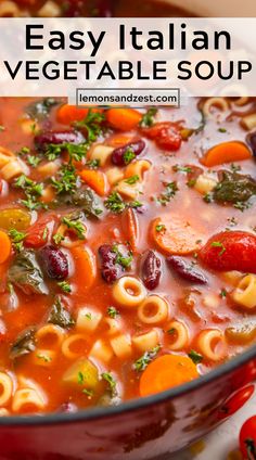 a red pot filled with pasta and vegetable soup on top of a white tablecloth