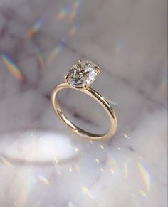 a close up of a diamond ring on a marble surface