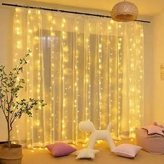 a living room with some lights on the curtains and a stuffed animal in front of it