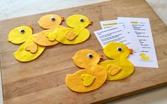 some felt ducks are sitting on a cutting board