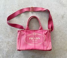 "Prada Canapa tote bag in good vintage condition. Pink canvas exterior with gold accents. Canvas interior, one interior zippered pocket and three interior open pockets. Original detachable adjustable shoulder strap included. Please refer to all photos for wear, specifically closeup photos for wear and fading throughout and several marks  stains. Bag is in overall great condition for its age.  Bag measures 11\" W x 7\" H x 6\" D Handle drop length of 5\" Shoulder strap drop length can be adjusted Vintage Tote Bag, Bag Prada, Pink Canvas, Boho Purses, Mini Tote Bag, Vintage Bag, Tote Bag Purse, Mini Canvas, Mini Tote