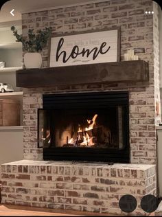 a brick fireplace with a sign above it that says home on the mantle and fire