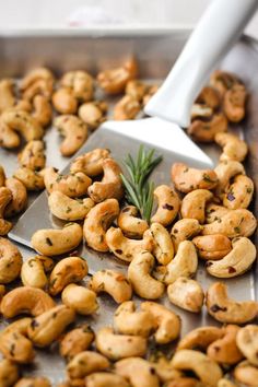 roasted cashews with rosemary being spooned over them