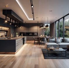 a living room filled with furniture next to a kitchen and dining room table on top of a hard wood floor