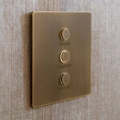 a metal switch plate mounted to the side of a wall with two dimmers