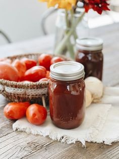 tomatoes and other vegetables sit in jars on a table