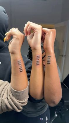 two people with matching tattoos on their arms