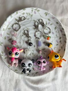 the littlest pet shop keychains have been placed on a plate