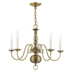 an antique brass chandelier with five white candles