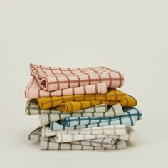 a stack of folded towels sitting on top of each other in different colors and patterns