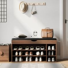 a wooden shoe rack with shoes and purses on it in front of a white wall