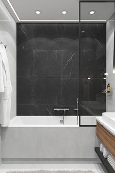 a white bath tub sitting next to a bathroom sink