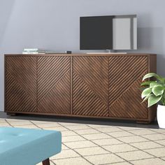 a living room with a large wooden cabinet in the center and a tv on top of it