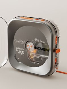 an orange cord is connected to a small metal box with a clock on the lid