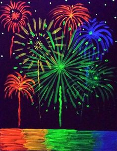 fireworks are lit up in the night sky over water and trees with bright lights on them