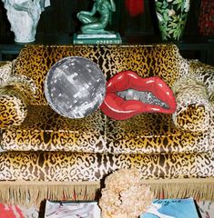 a leopard print chair with red lips and disco ball on it