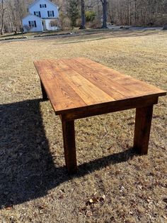 a wooden table sitting in the middle of a field