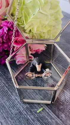 a vase filled with flowers sitting on top of a wooden table next to a small figurine