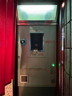 the door to an elevator is open and there are red curtains on either side of it