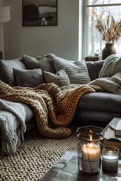 a living room filled with furniture and a blanket on top of a couch next to a window