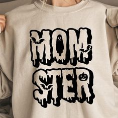 "Celebrate the spooky side of motherhood with this fierce 'Momster' t-shirt! Perfect for moms who rule the household like a true monster, this shirt combines humor and horror for a fun twist. Featuring bold, gothic-style lettering with spooky accents, it's ideal for Halloween or any time of year. Made from soft, comfortable fabric, this tee is both stylish and practical--just like the multitasking mom in your life! Whether you're chasing after little monsters or enjoying some time off, this shirt shows that being a 'Momster' is all about having fun and embracing your spooky side." Halloween Moms, Call My Mom, Gothic Style, Little Monsters, Gothic Fashion, Mom Shirts, Halloween Shopping, Gender Neutral, Bathing Beauties