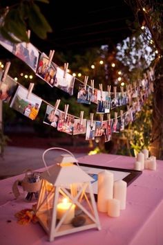 a table topped with candles and pictures hanging from clothes pins on the clothes pegs